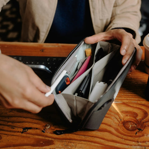 a guy using the black small tech pouch