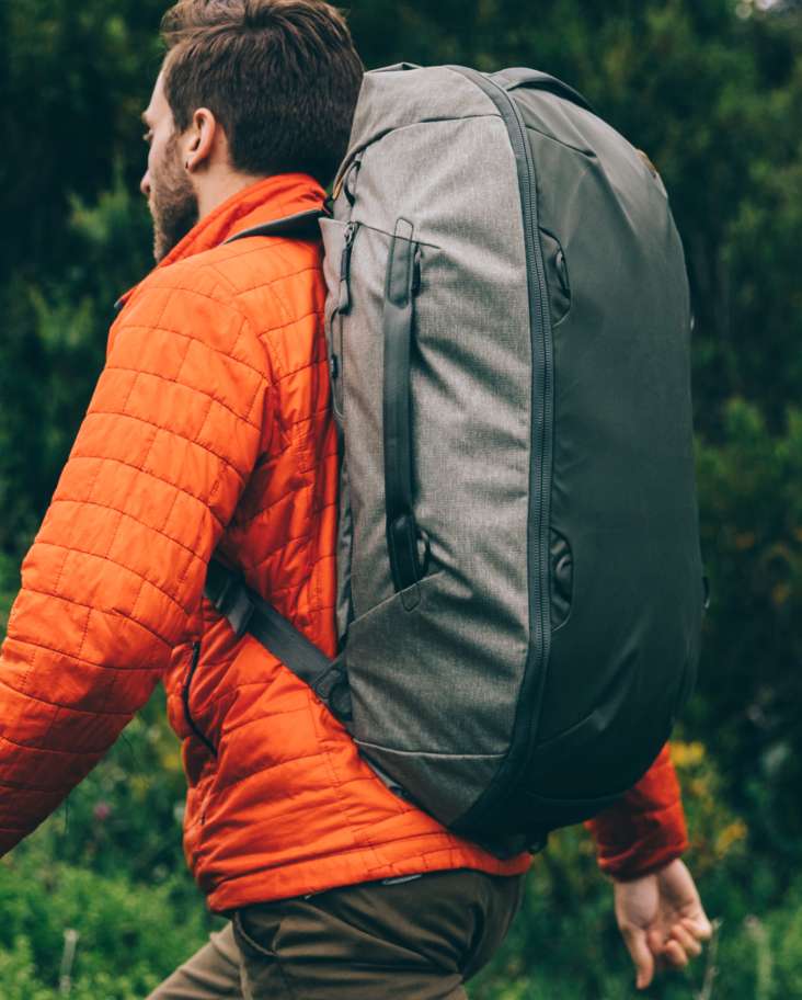 A man on a hike, wearing a Travel Duffelpack 65L
